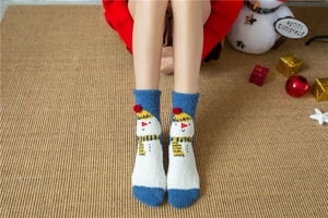 Detailed view of plush coral fleece snowman socks with 3D red pom-poms for Christmas