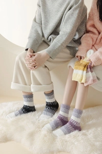 Gros plan de chaussettes rayées en polaire corail sur tapis moelleux pour l'hiver