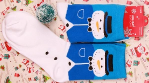Close-up of festive cotton crew socks featuring a woven snowman design and custom packaging