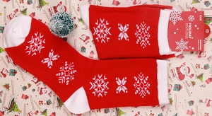 Detail of red Christmas crew socks with snowflake patterns and festive holiday packaging