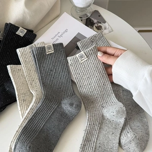 Detailed texture of retro ribbed knit crew socks with colorful flecks and woven label
