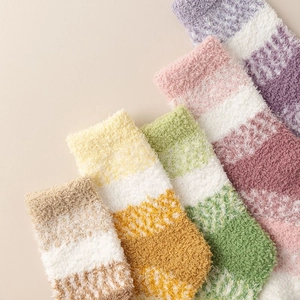 Gros plan de chaussettes d'hiver en polaire corail douce avec texture pelucheuse et rayures