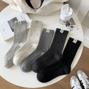 Detailed view of five pairs of rib-knit crew socks with dog patches in various colors