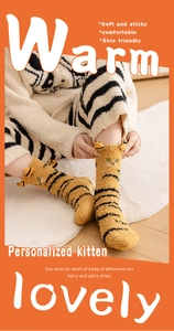 Detail of yellow cat-pattern coral fleece socks with 3D ears and warm plush texture