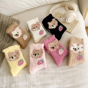 Detail of colorful coral fleece socks with cute bear and strawberry embroidery