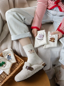 Dettaglio di calze in cotone con ricami a cartoni animati e motivi a pois colorati
