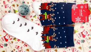 Detail of navy blue knitted Christmas socks with reindeer patterns and snowflakes