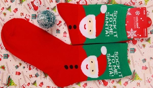 Detail of cotton Christmas socks featuring Santa Claus pattern and festive packaging