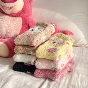 Close-up of thick coral fleece socks with colorful cartoon bears and strawberry patterns