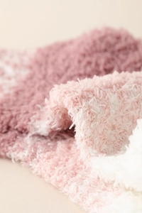 Détail macro du tissu polaire corail rose et blanc avec une texture douce et chaude