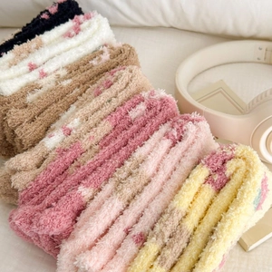 Detailed close-up of colorful plush coral fleece socks with cute polka dot patterns