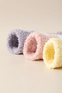 Détail de la texture des chaussettes en polaire corail violettes, roses et jaunes