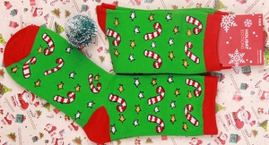 Detail view of green Christmas socks with candy cane patterns and red heel accents