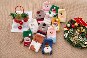 Detail of soft coral fleece Christmas socks featuring 3D cartoon reindeer and Santa patterns