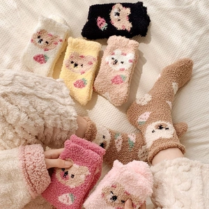 Detail of soft coral fleece socks with cute cartoon bear and strawberry patterns