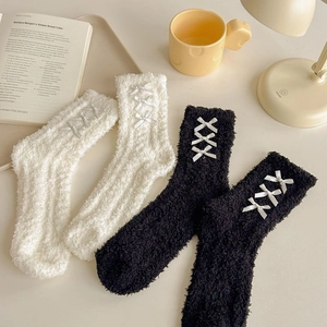 Detail of coral fleece socks with ribbon bow design for women's winter warmth