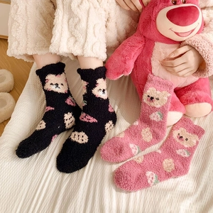 Close-up of thick coral fleece socks featuring cute bear and strawberry patterns