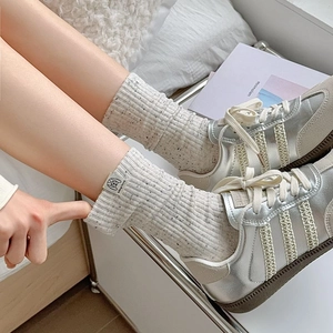 Retro cream speckled knit mid-calf socks paired with stylish metallic silver sneakers
