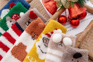 Close-up of thick coral fleece Christmas socks with 3D cartoon animal characters