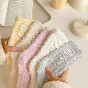 Detail of coral fleece winter socks set with satin bows in five soft pastel colors