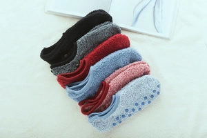 Detail of colorful non-slip floor socks with silicone grips on warm plush background
