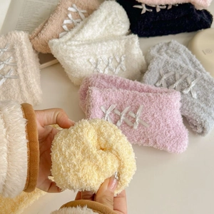 Detail of coral fleece winter socks with soft bow ties in various macaron colors