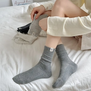 Close-up of ribbed cotton crew socks with speckle knit and cute puppy woven label