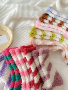 Close-up of thick coral fleece winter socks with classic colorful checkerboard patterns
