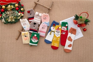 Detail of coral fleece Christmas socks with 3D cartoon reindeer and Santa motifs