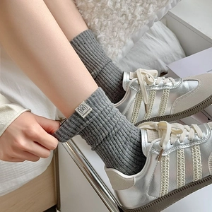 Grey ribbed mid-calf socks with 'dog love' woven label paired with stylish sneakers
