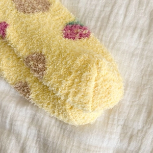 Close-up of yellow coral fleece socks featuring strawberry and heart patterns