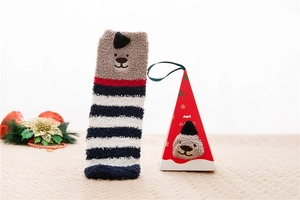 Detail of coral fleece Christmas socks with dog embroidery and festive gift box