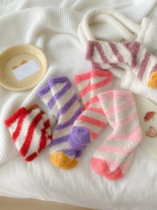 Detailed close-up of striped coral fleece socks in assorted soft pastel color combinations