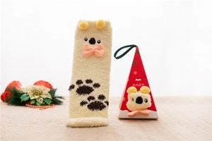 Detail of coral fleece Christmas sock with 3D ears and koala paw print in festive gift box
