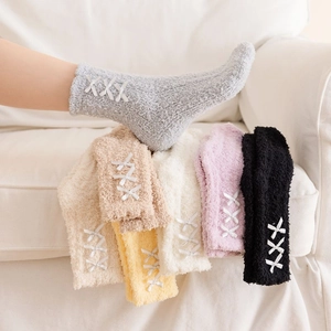 Detail of coral fleece thick warm socks with elegant triple ribbon bow decorations