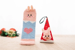 Close-up of pink coral fleece socks with pig embroidery and matching 3D gift box packaging