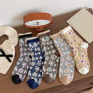 Lot de cinq paires de chaussettes en coton à fleurs avec bordure en dentelle sur bois