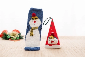 Detail of coral fleece Christmas snowman sock with red gift box on knit background