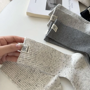 Detail of knitted rib texture and adog love fabric label on vintage melange socks