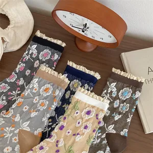 Détail de chaussettes vintage en coton à fleurs avec bordure dentelle sur bois noble