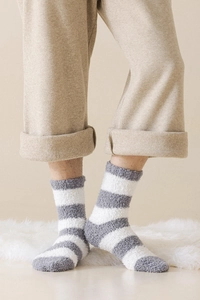Detail of warm grey striped coral fleece socks showing soft texture on a cozy rug