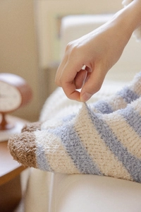 Close-up of stretchy striped coral fleece socks showing soft plush texture and elasticity