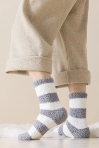 Macro detail of plush grey and white striped coral fleece socks for winter warmth