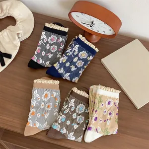 Lot de cinq chaussettes vintage à fleurs avec bordure en dentelle sur bois chaleureux