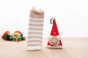 Detail of coral fleece bear socks with 3D elements in a red Christmas gift box