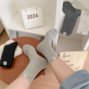 Detailed shot of knitted crew socks with animal patches and speckled vintage texture