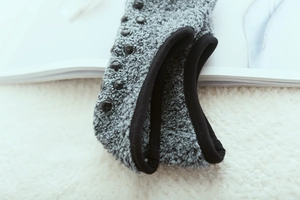 Detail of grey thermal floor socks showing anti-slip silicone dots and plush lining