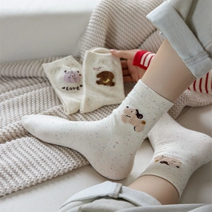 Simpatici calzini in cotone beige con ricami di animali e motivi colorati a macchioline
