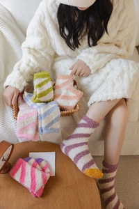 Detailed texture of colorful striped coral fleece socks in a cozy home setting