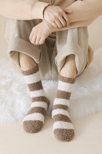 Close-up of fluffy brown and white striped coral fleece warm winter socks for men
